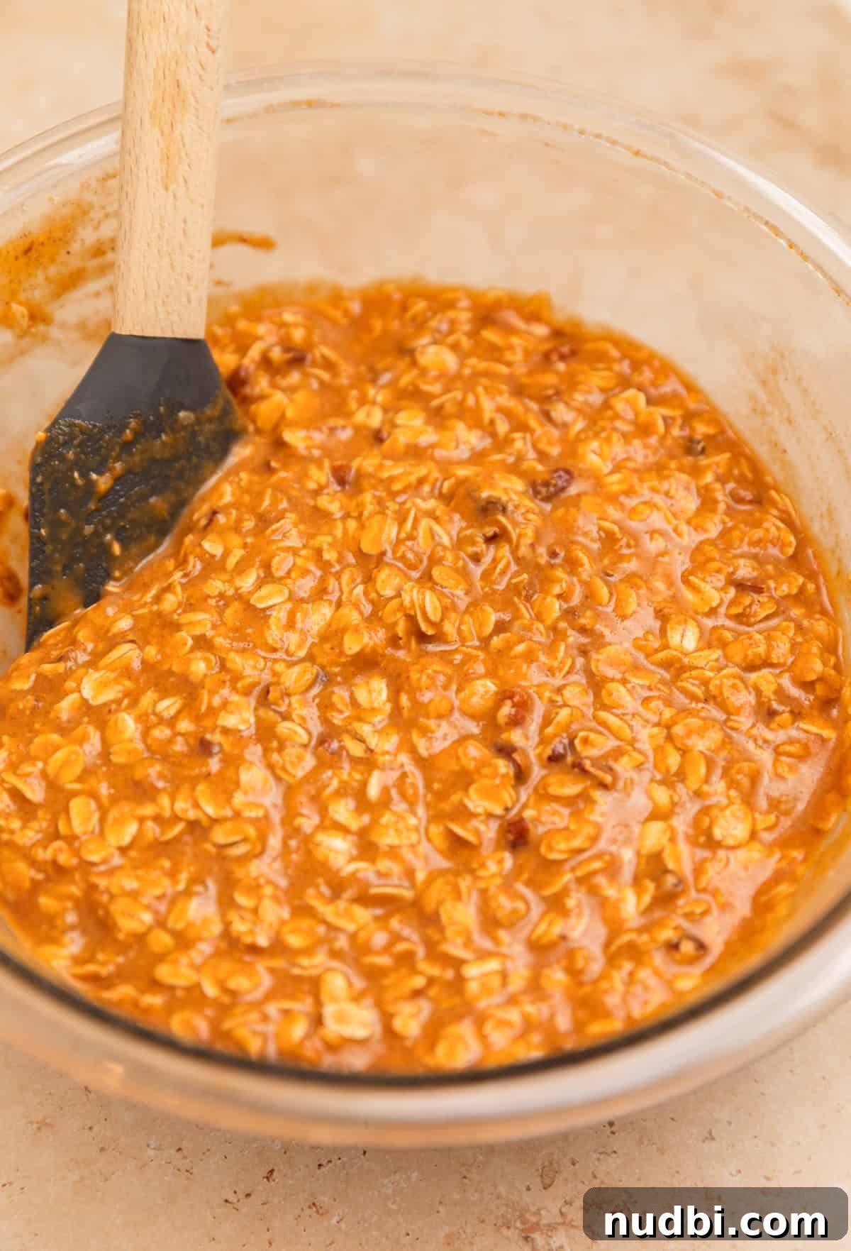 Spatula propped in bowl with pumpkin oatmeal mixture.