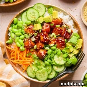 Teriyaki Salmon Rice Bowl with Scallions and Sesame 12 Teriyaki salmon bites in bowl with rice and vegetables.