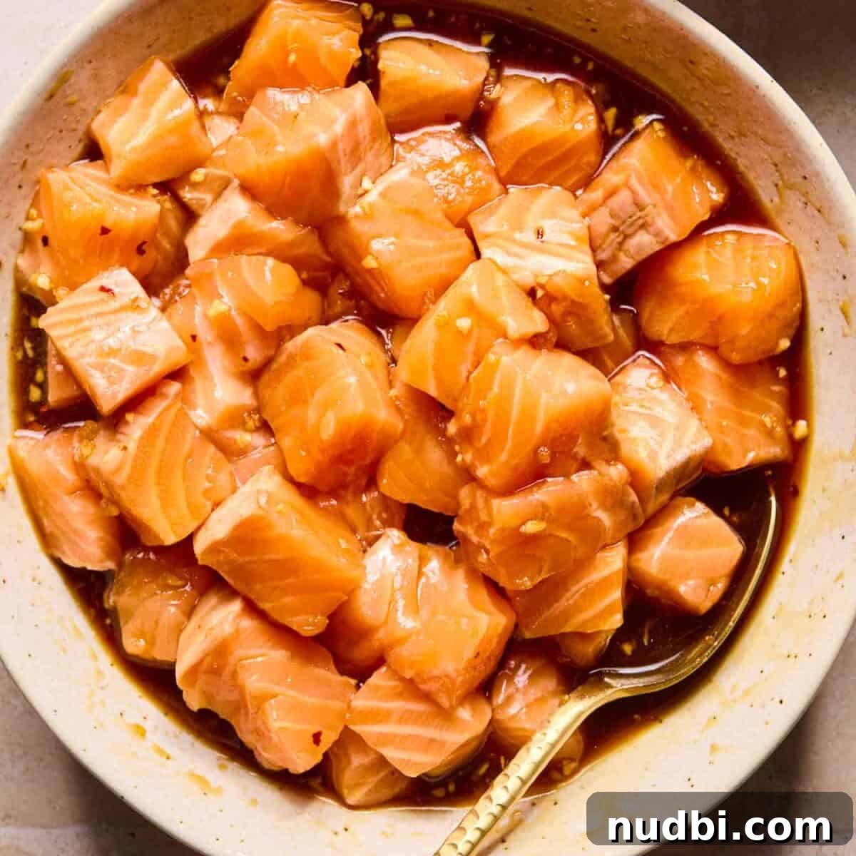 Teriyaki Salmon Rice Bowl with Scallions and Sesame 6 Bowl with cubed salmon in teriyaki marinade.