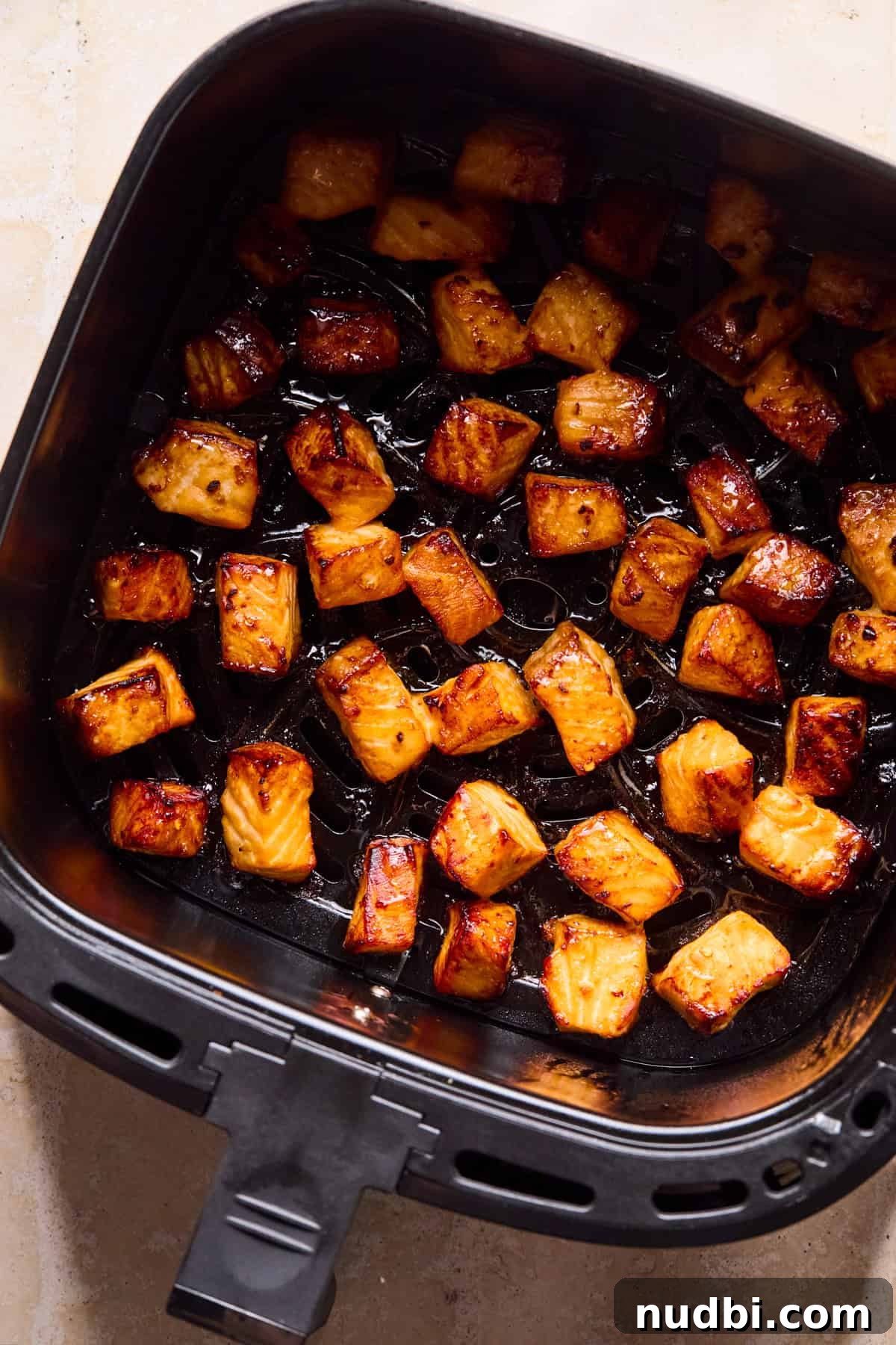 Teriyaki Salmon Rice Bowl with Scallions and Sesame 8 Air fryer with teriyaki salmon bites cooked.