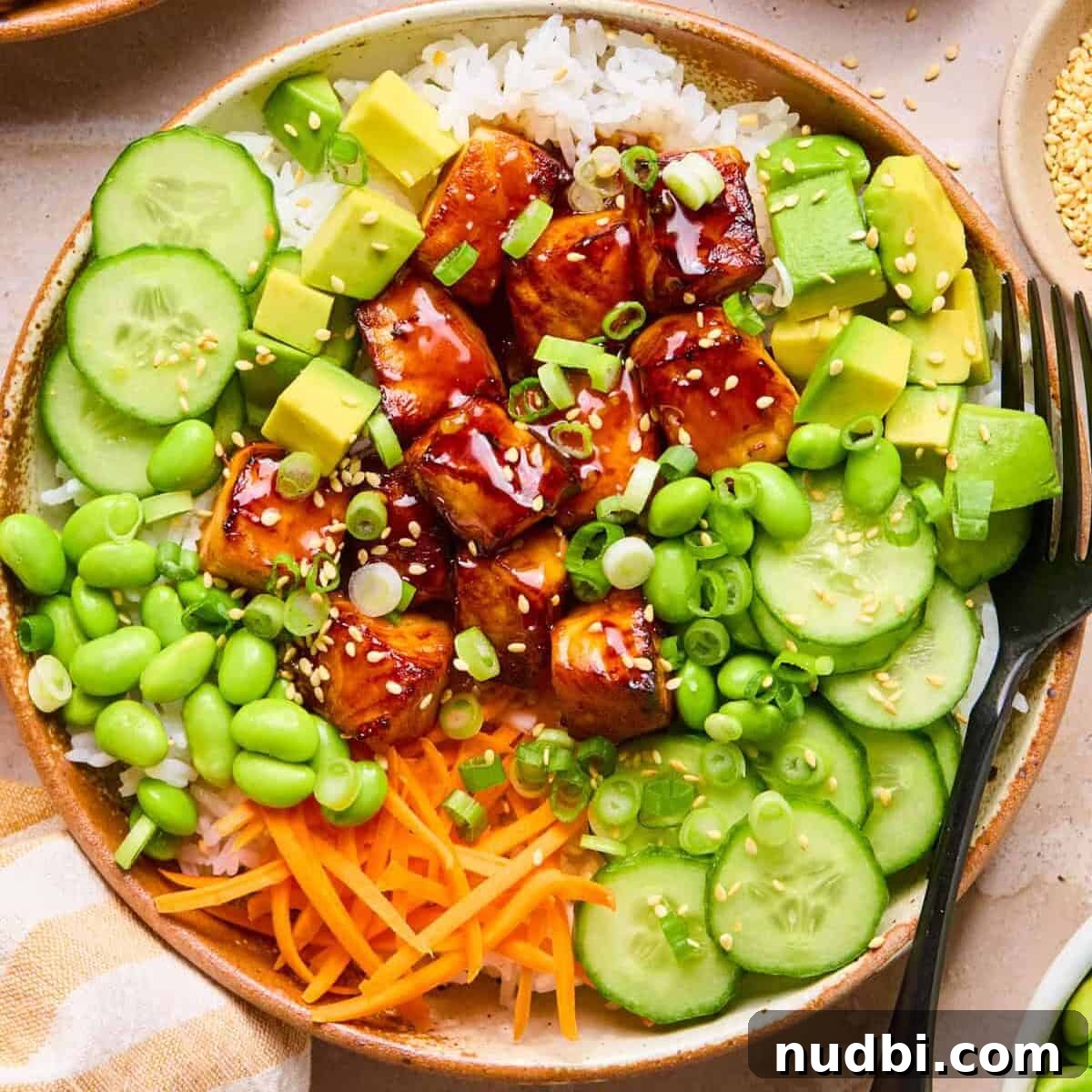Teriyaki Salmon Rice Bowl with Scallions and Sesame 10 Bowl with teriyaki salmon, rice, green onion, cucumber and more.
