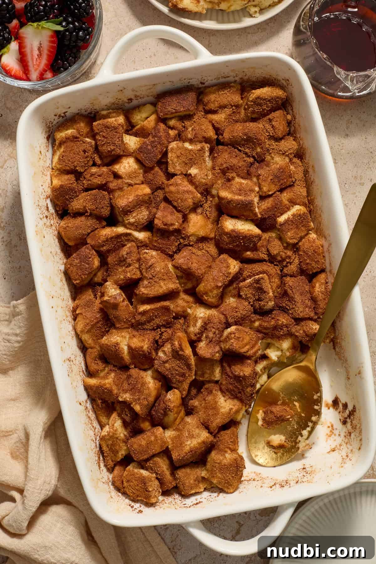 Overnight French Toast Casserole with Maple Cinnamon Glaze 11 Pan with baked French toast and serving spoon.