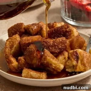 Overnight French Toast Casserole with Maple Cinnamon Glaze 12 Maple syrup being poured over French toast casserole.