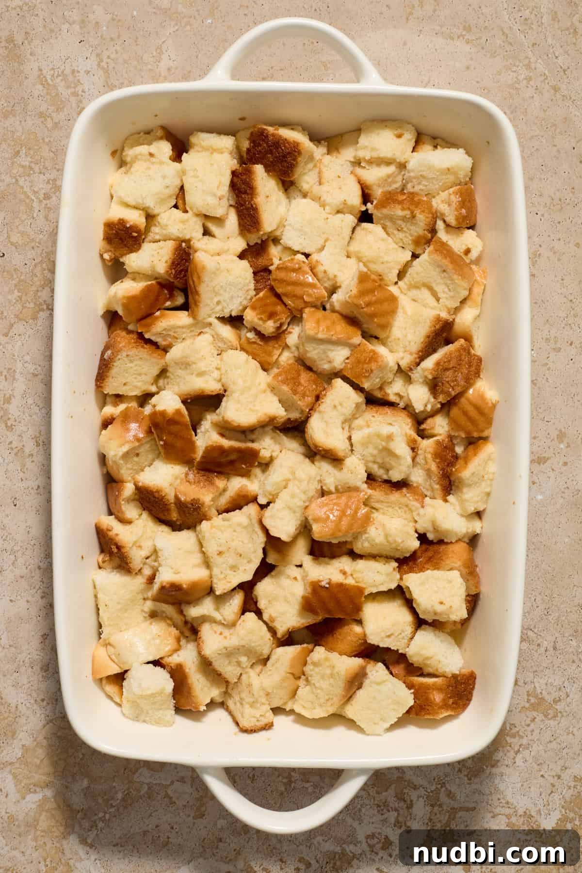 Overnight French Toast Casserole with Maple Cinnamon Glaze 7 Baking pan with egg soaked bread cubes.