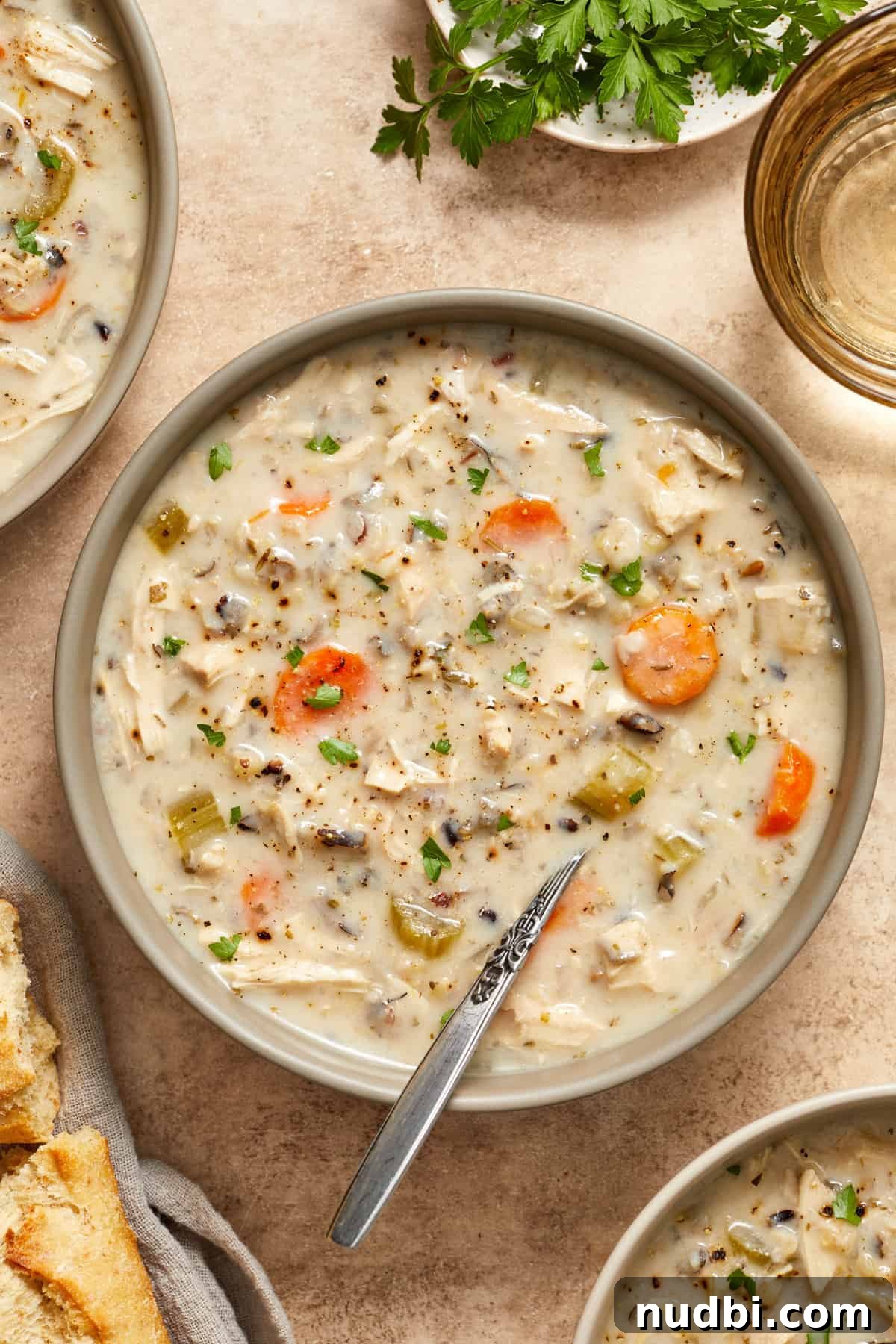 Slow-Cooker Chicken and Wild Rice Soup Recipe 2 Crockpot chicken and wild rice soup in bowl with spoon scooping in.