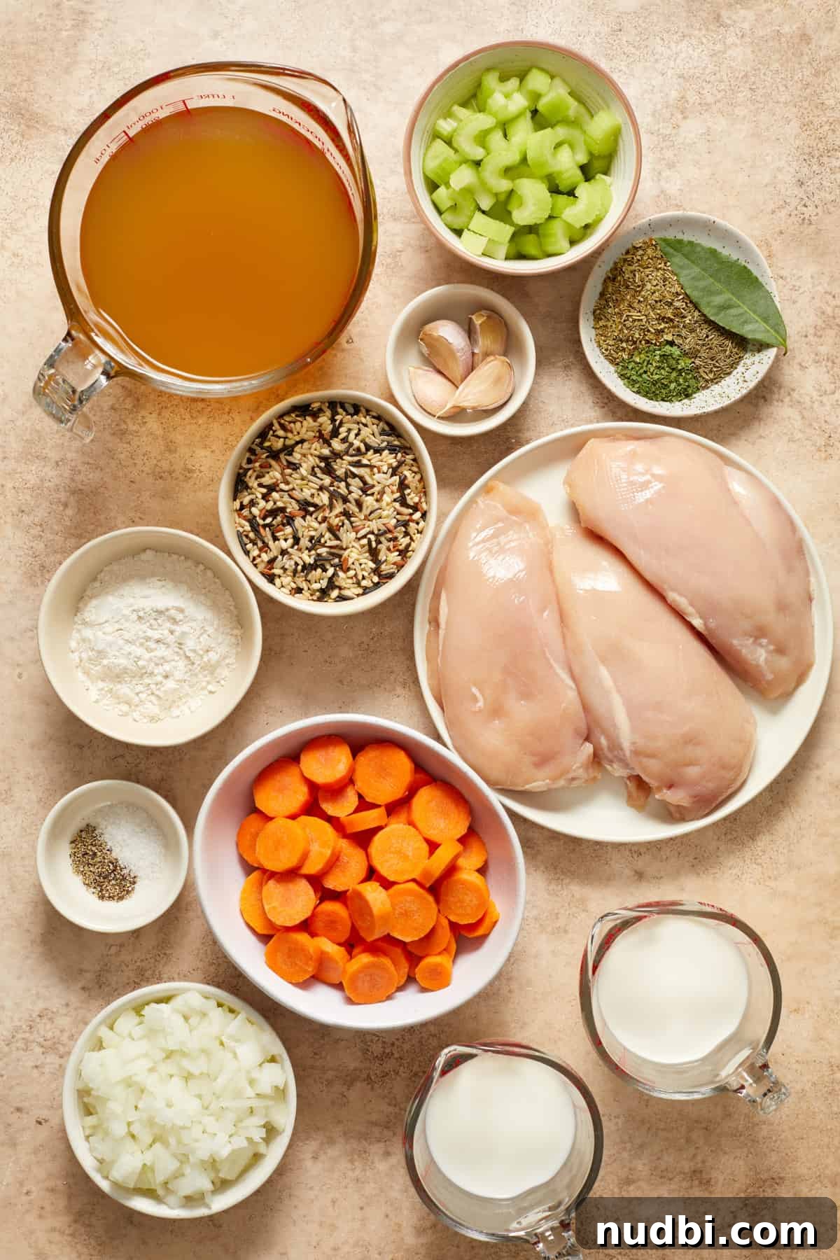 Slow-Cooker Chicken and Wild Rice Soup Recipe 3 Broth, celery, carrots, chicken breast and other soup ingredients arranged on counter.
