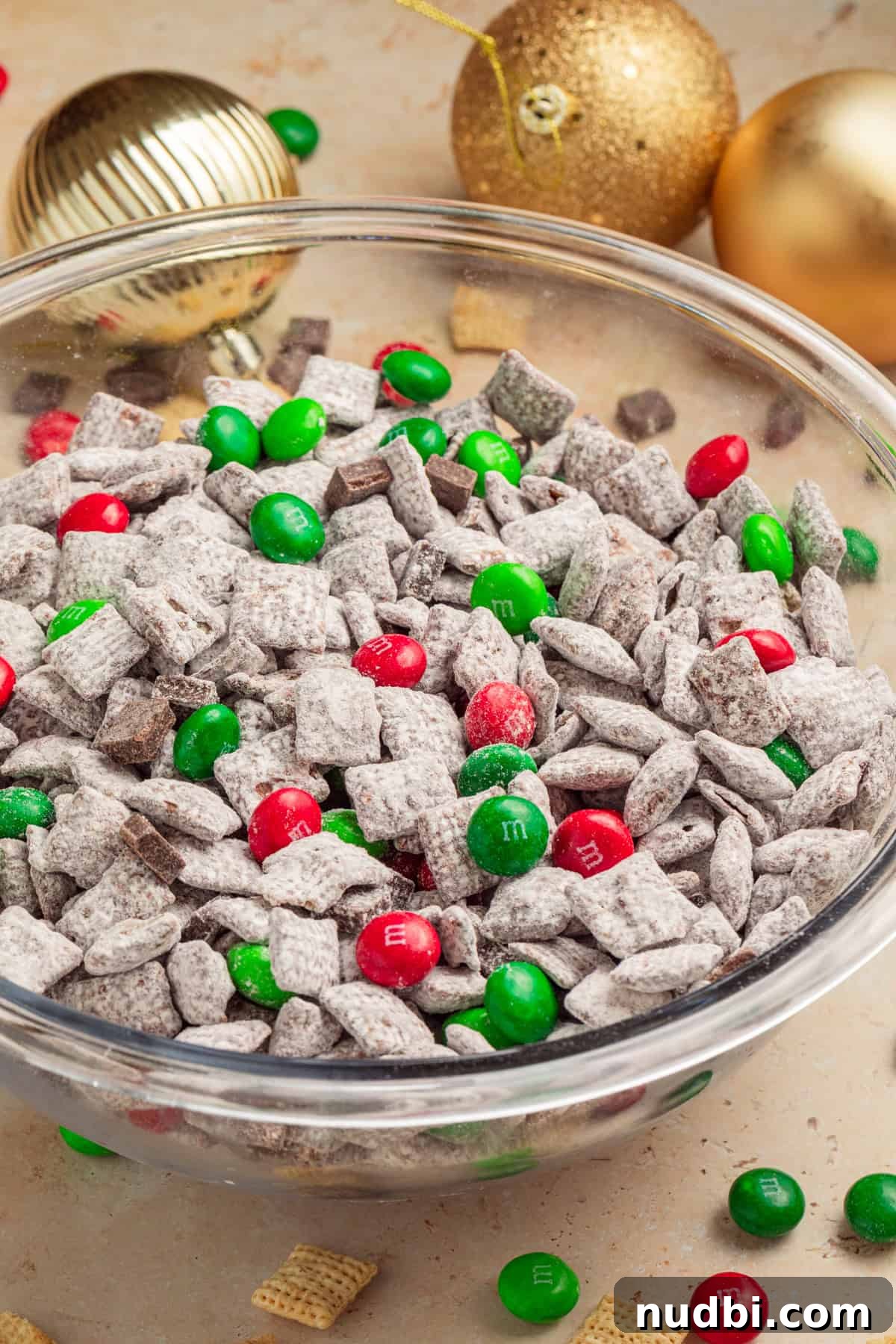 Christmas Puppy Chow Recipe: Festive Snack Mix for Holiday Parties 2 Christmas puppy chow in bowl with red and green candies.