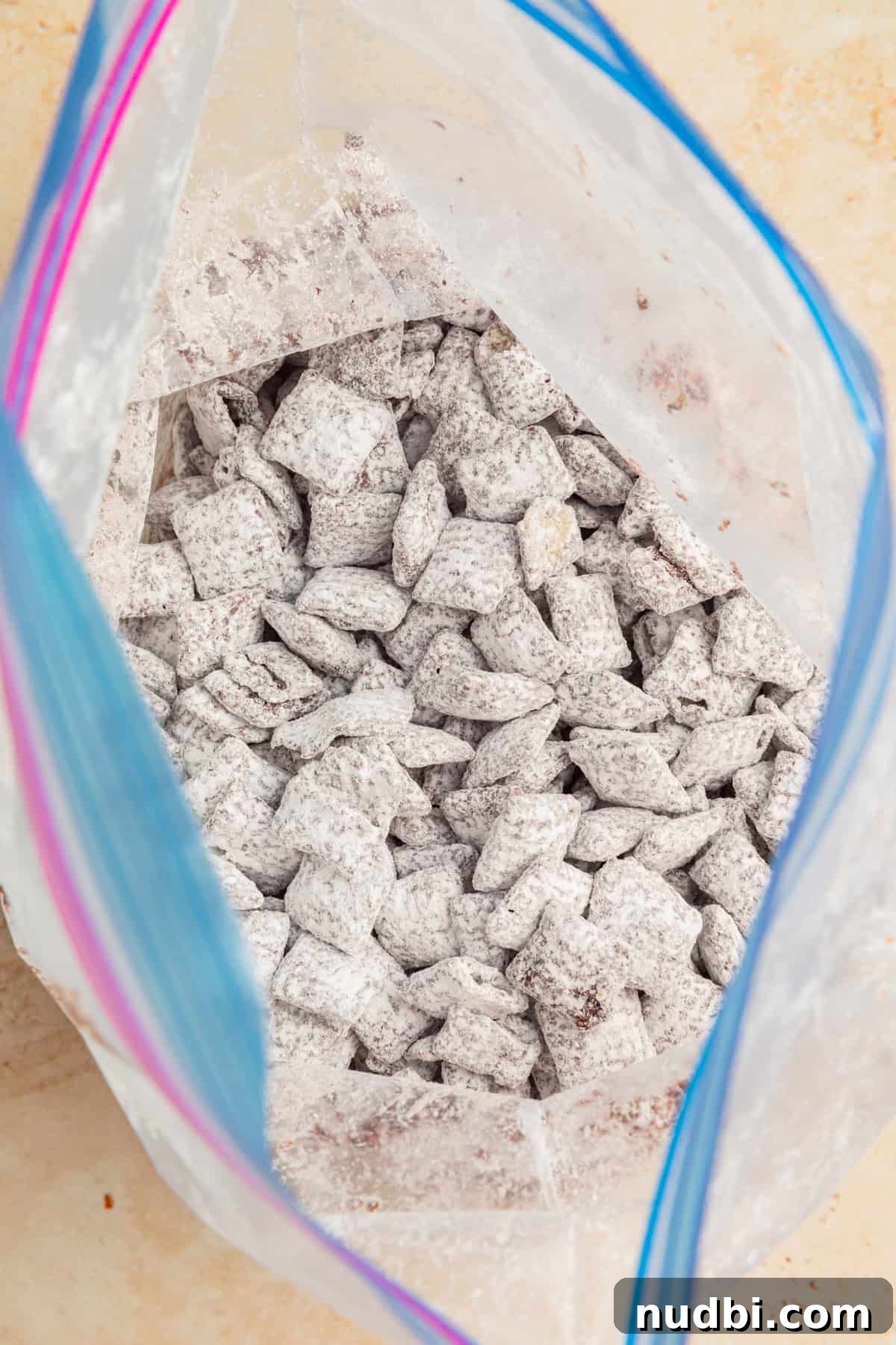 Christmas Puppy Chow Recipe: Festive Snack Mix for Holiday Parties 8 Powdered sugar coated cereal in bag.
