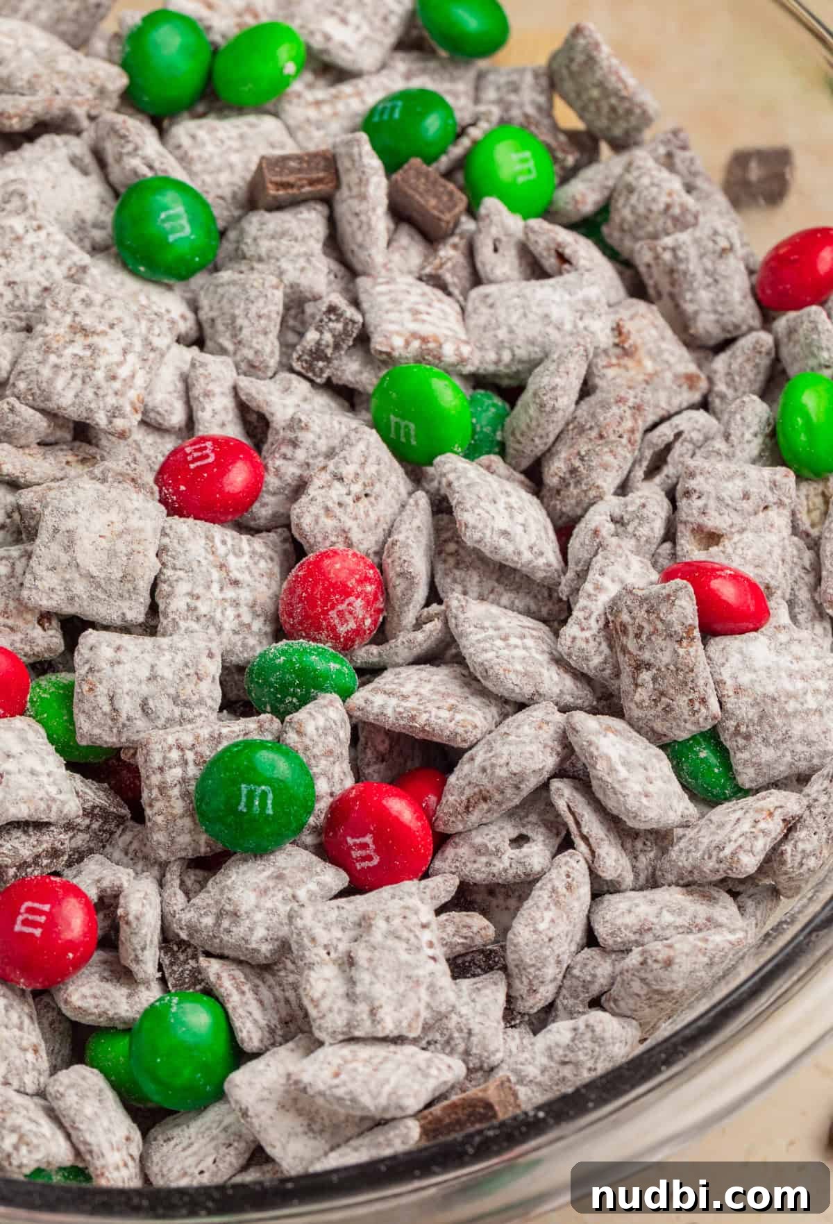 Christmas Puppy Chow Recipe: Festive Snack Mix for Holiday Parties 10 Close up view of mint chocolate Christmas muddy buddies in bowl.