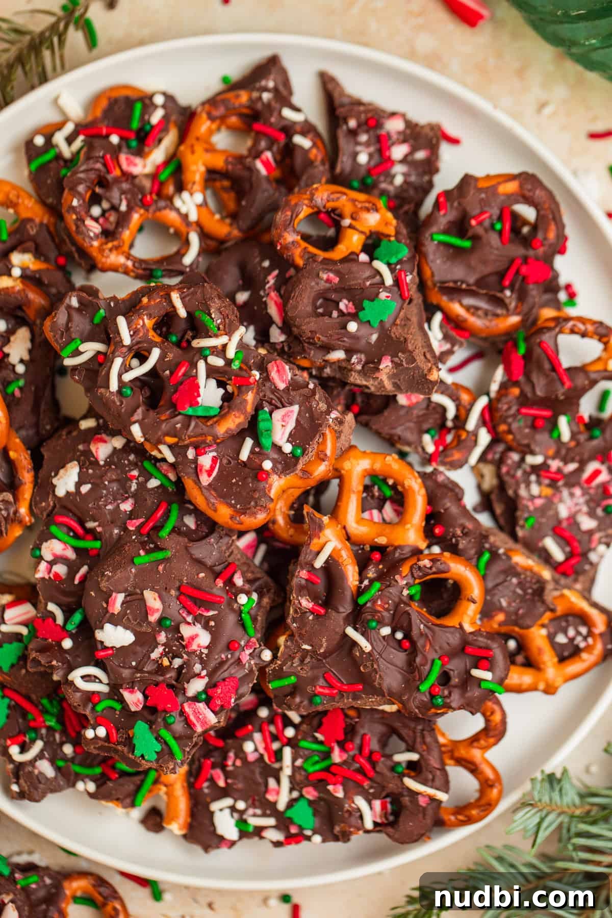 Peppermint Dark Chocolate Pretzel Bark Recipe for Holiday Treats 2 Plate with pretzel and chocolate mint bark topped with red and green sprinkles.
