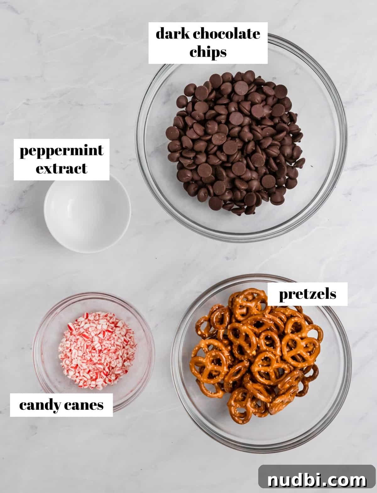 Peppermint Dark Chocolate Pretzel Bark Recipe for Holiday Treats 3 Pretzels, chocolate chips, mint extract and candy canes on counter in bowls.
