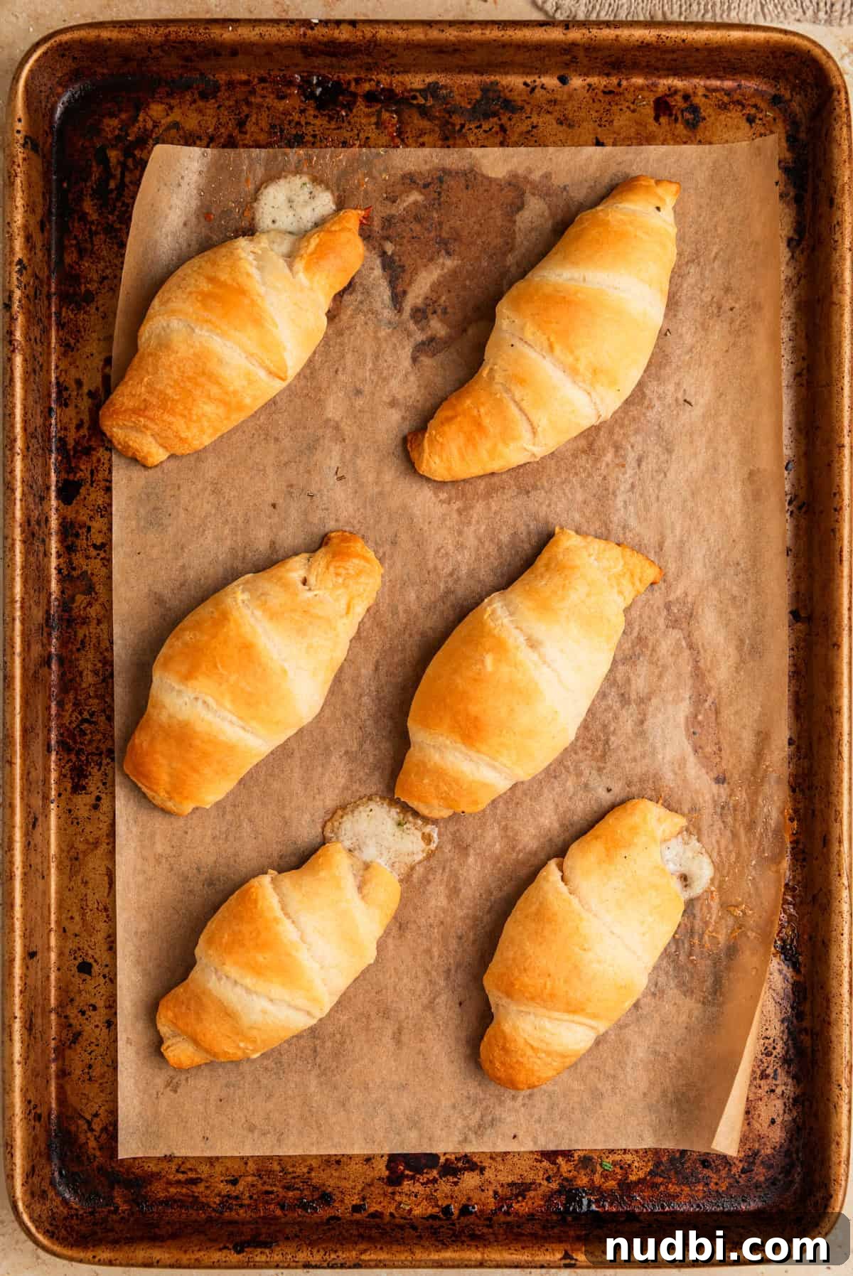 Baked Brie Crescent Rolls with Honey & Cranberry Jam 7 Baked stuffed crescent rolls parchment lined baking sheet.
