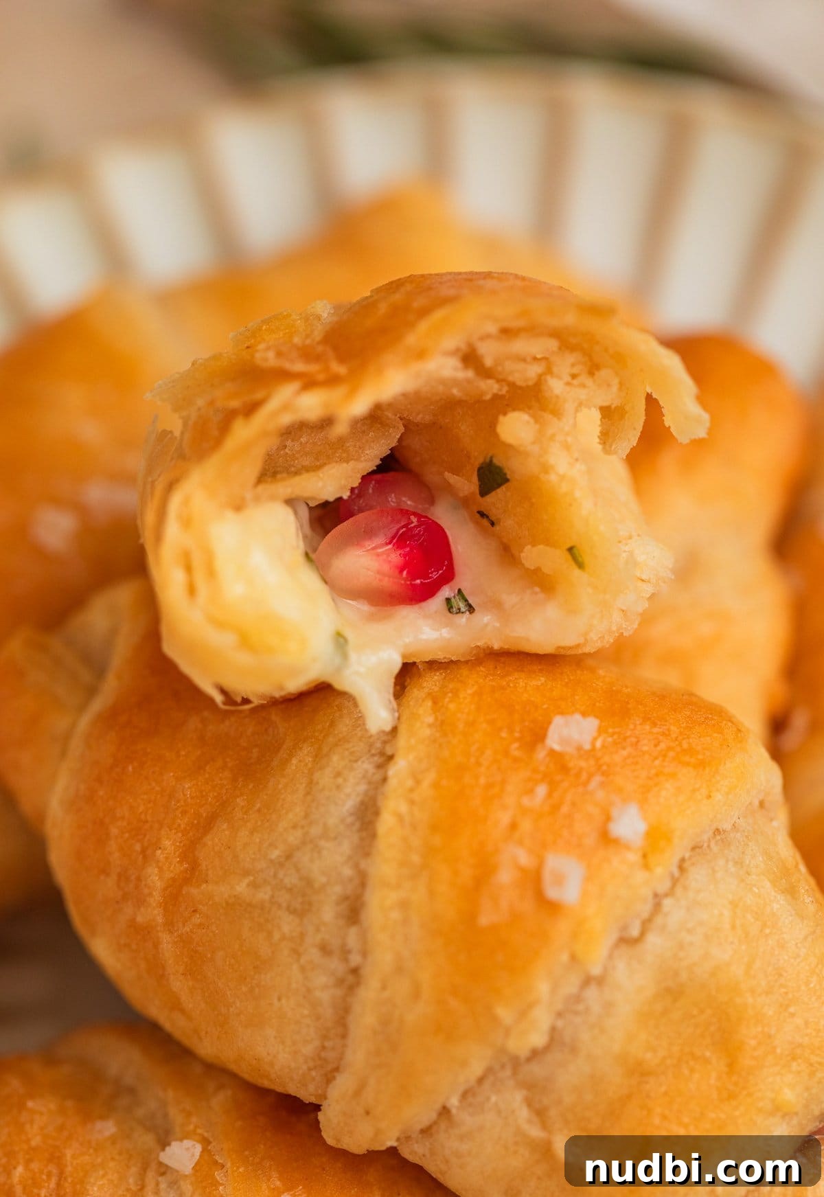 Baked Brie Crescent Rolls with Honey & Cranberry Jam 9 Halved crescent roll with cheese and pomegranate inside.