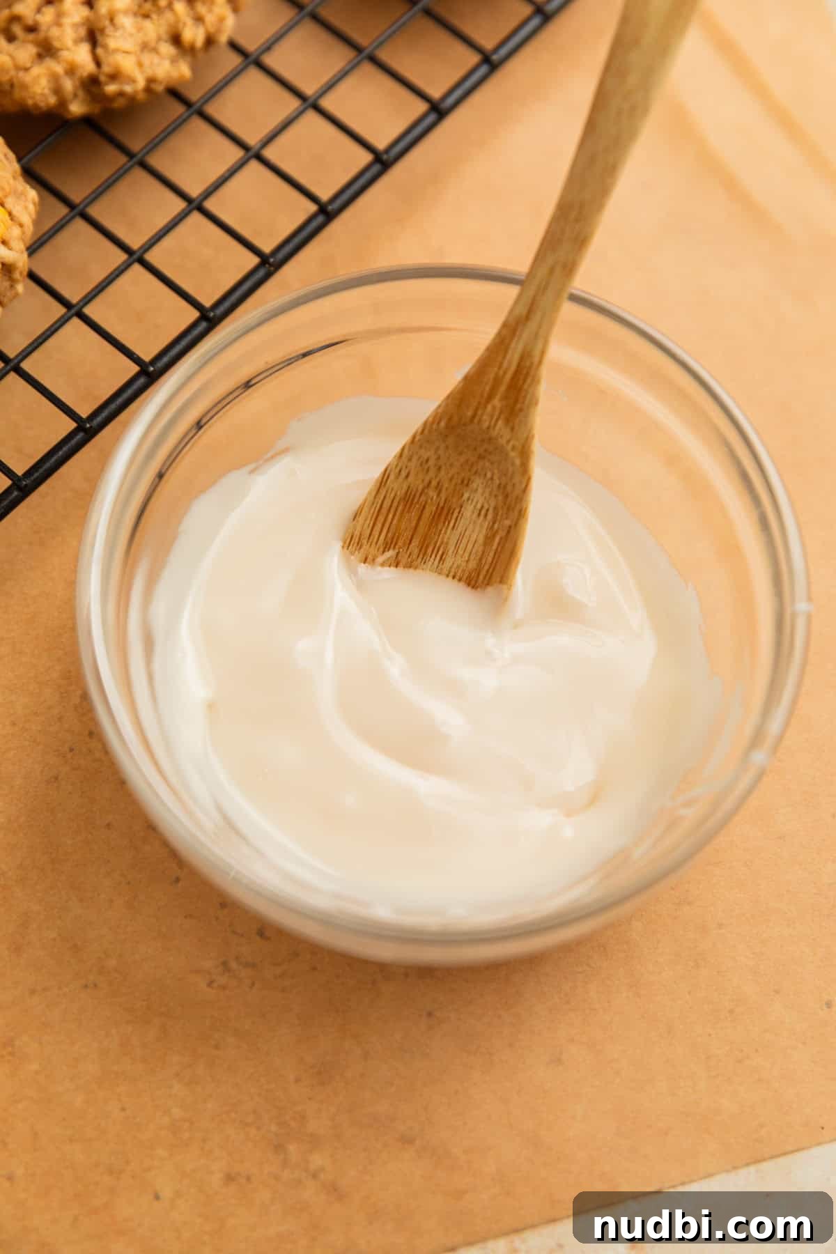 Cinnamon Roll Breakfast Cookies: Soft, Swirled Morning Treats 11 Icing glaze in bowl with wood spoon.