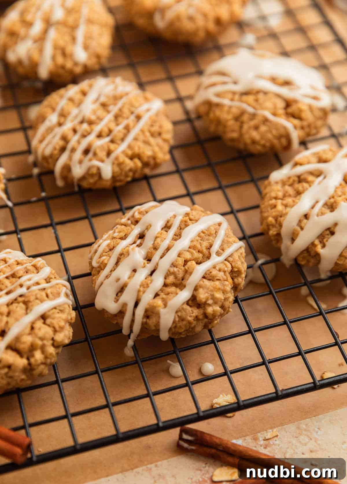 Cinnamon Roll Breakfast Cookies: Soft, Swirled Morning Treats 12 Iced oatmeal cookies on wire rack.