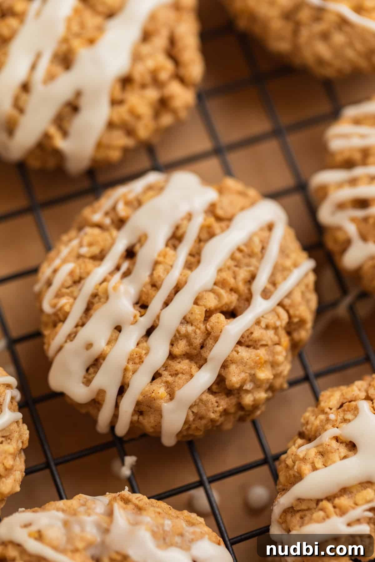 Cinnamon Roll Breakfast Cookies: Soft, Swirled Morning Treats 13 Oatmeal cinnamon cookies on cooling rack with icing drizzled over top.