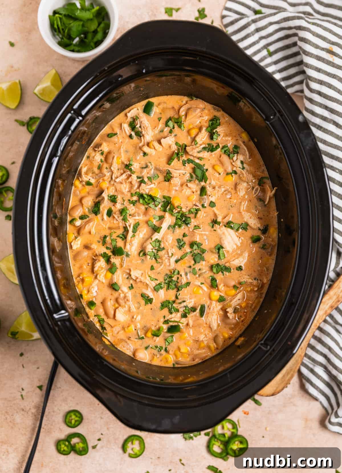 Creamy Slow Cooker White Chicken Chili Recipe 12 Crock pot with cream cheese white chicken chili topped with chopped cilantro.