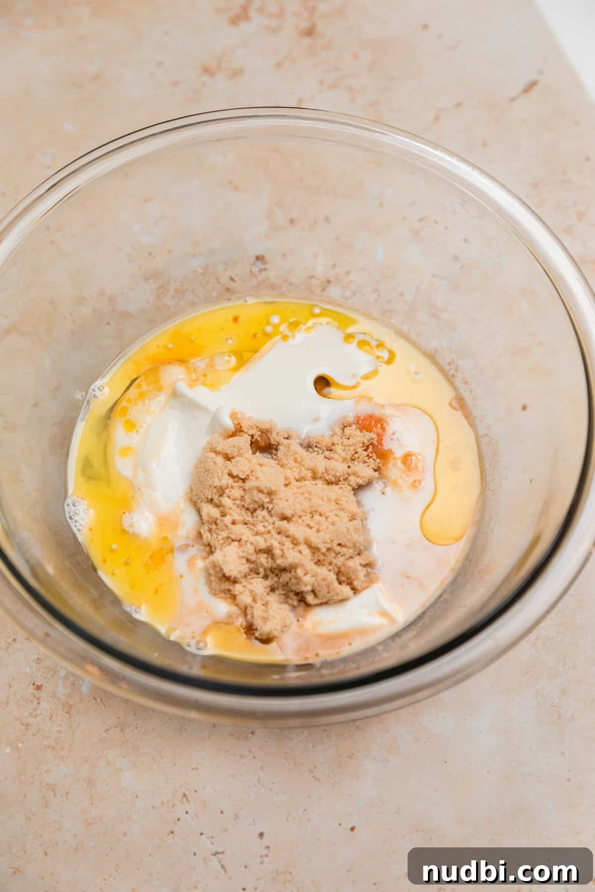 Light and Fluffy Greek Yogurt Donuts Recipe 4 Egg, brown sugar, milk, vanilla yogurt and vanilla in glass bowl.