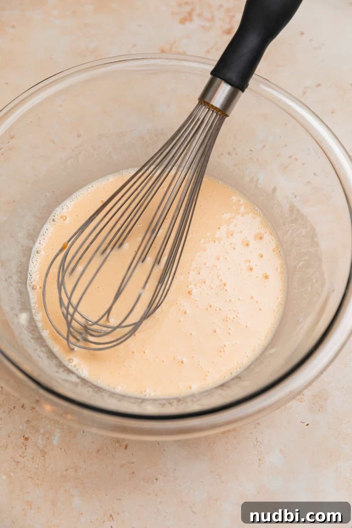 Light and Fluffy Greek Yogurt Donuts Recipe 5 Whisk in bowl with donut ingredients.