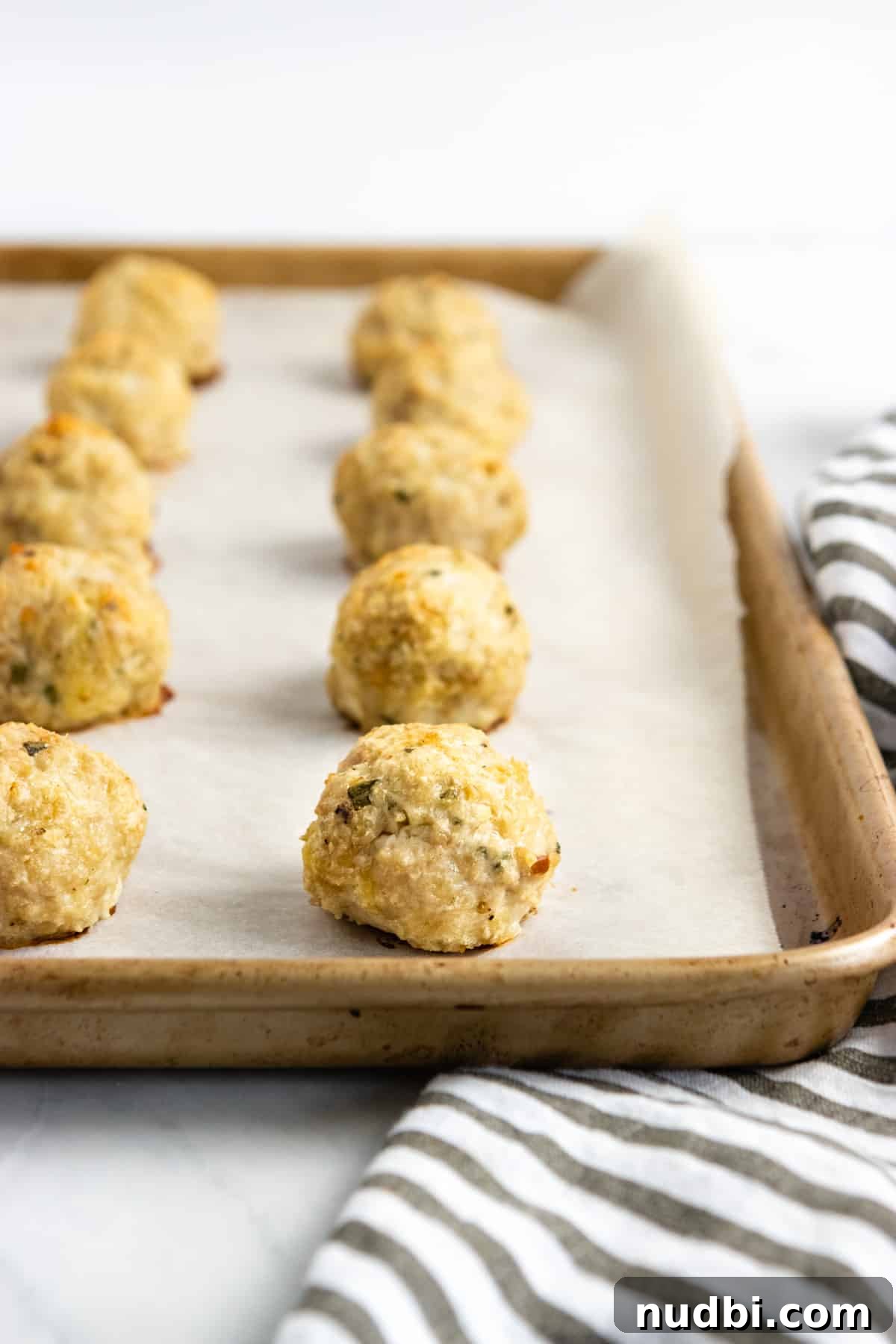 Parmesan & Rosemary Baked Chicken Meatballs Recipe 2 Chicken meatballs cooked on sheet pan.
