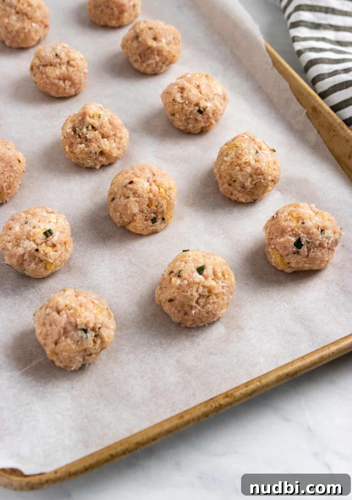 Parmesan & Rosemary Baked Chicken Meatballs Recipe 4 Rolled meatballs on baking sheet.