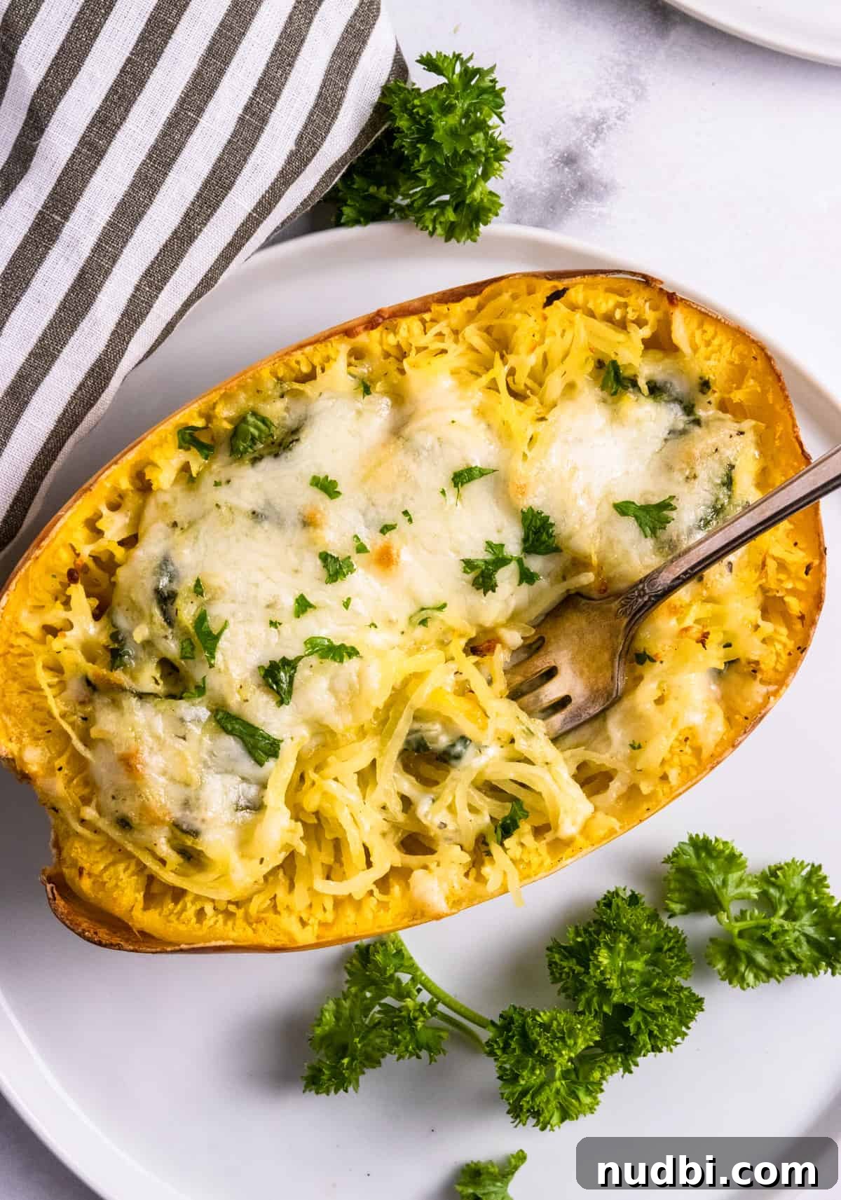 Pesto stuffed spaghetti squash with fork in it.