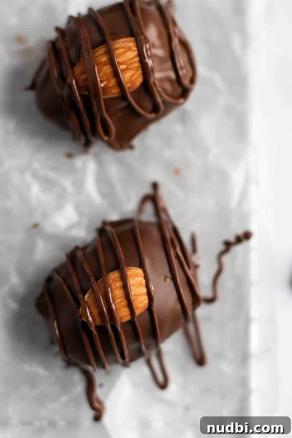 Homemade Almond Joy Bars Recipe with Coconut, Chocolate & Almonds 3 Overhead view of chocolate coated coconut candy with almond and chocolate drizzle.