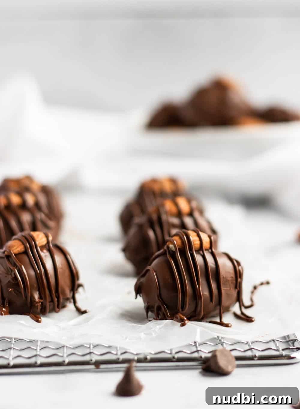 Homemade Almond Joy Bars Recipe with Coconut, Chocolate & Almonds 4 Homemade almond joy bars with chocolate drizzle on wax paper.