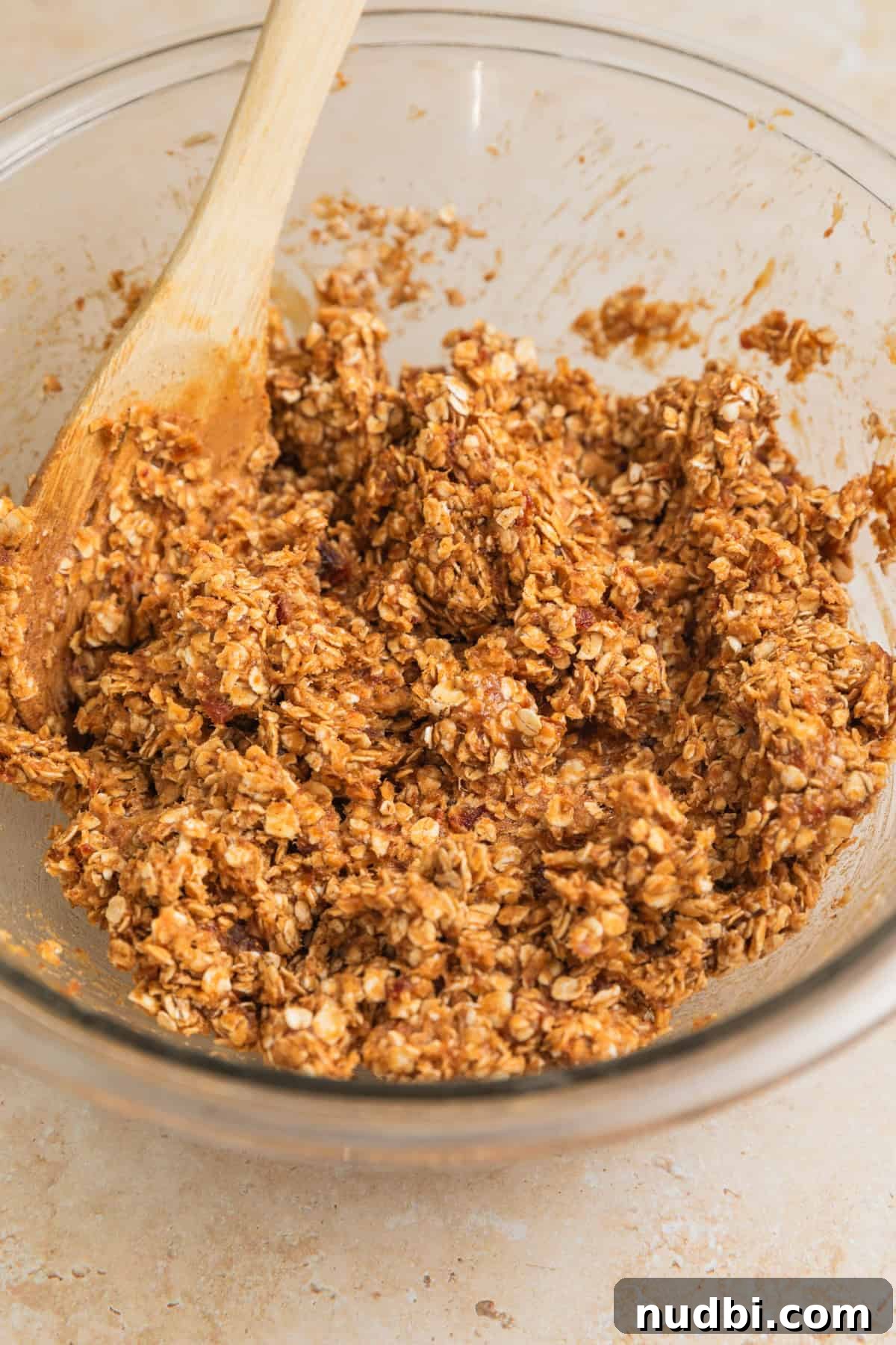 Homemade Trail Mix Bars Recipe – Portable Snack Bars for Hiking 7 Peanut butter oatmeal mixture in bowl with spoon.