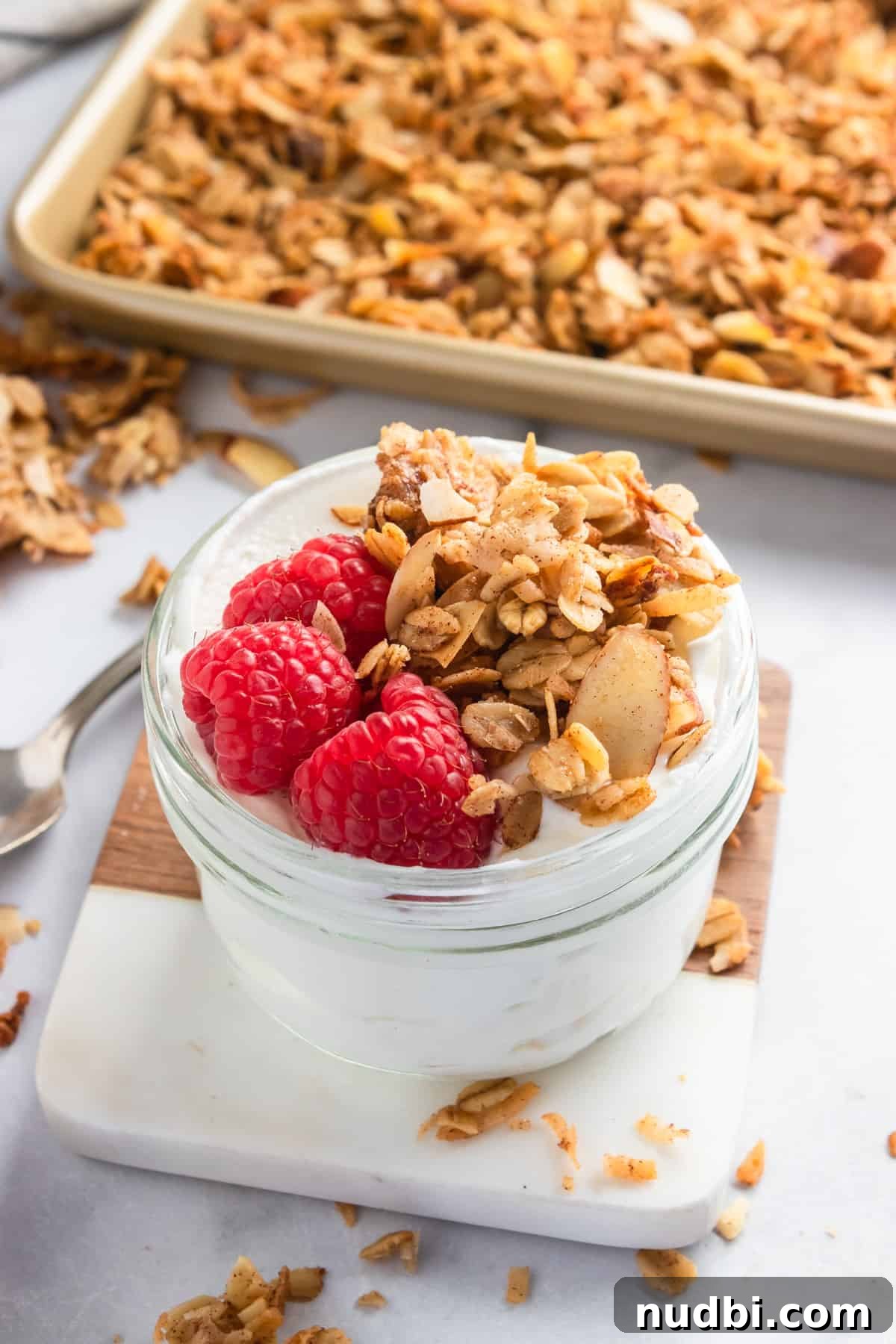 Crunchy Homemade Granola Recipe with Oats and Nuts 6 Yogurt topped with berries and granola in jar with baking sheet of granola.