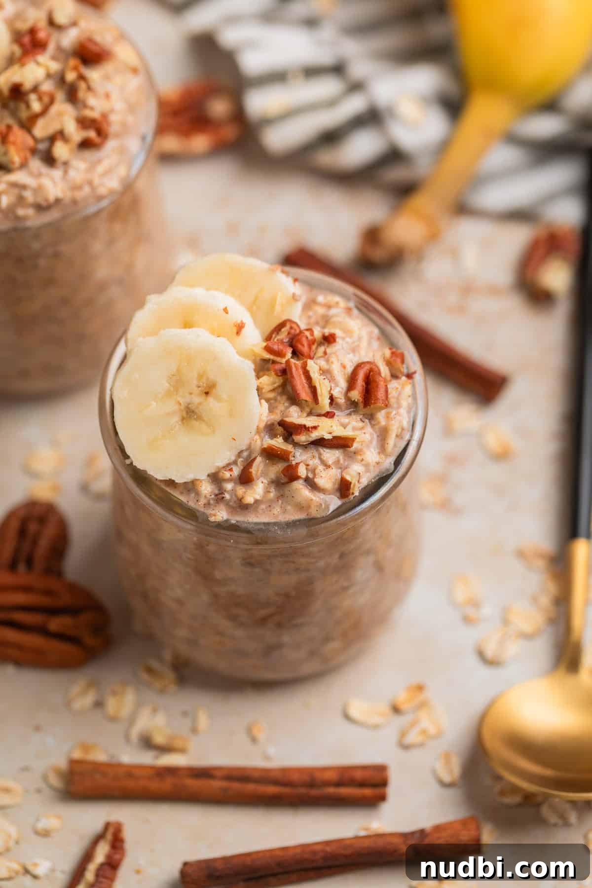 Banana Bread Overnight Oats Recipe for Creamy Breakfast Bliss 2 Banana bread overnight oats in jar topped with sliced bananas and chopped pecans.
