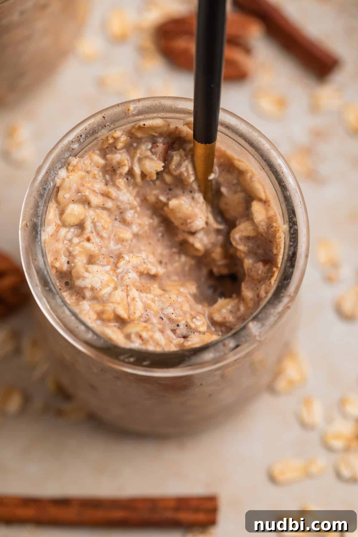 Banana Bread Overnight Oats Recipe for Creamy Breakfast Bliss 3 Spoon scooping into jar with banana overnight oats.