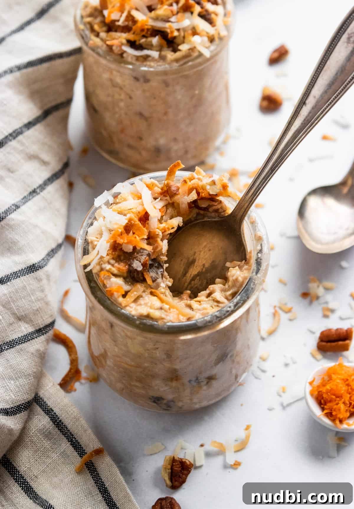 Carrot Cake Overnight Oats Recipe for Make-Ahead Breakfast 6 Carrot cake overnight oats in jar with spoon scooping in.