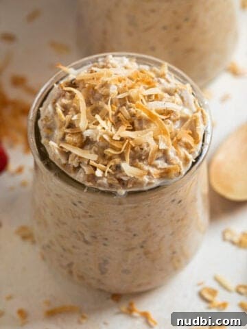 Coconut cream pie overnight oatmeal in a jar topped with toasted coconut.