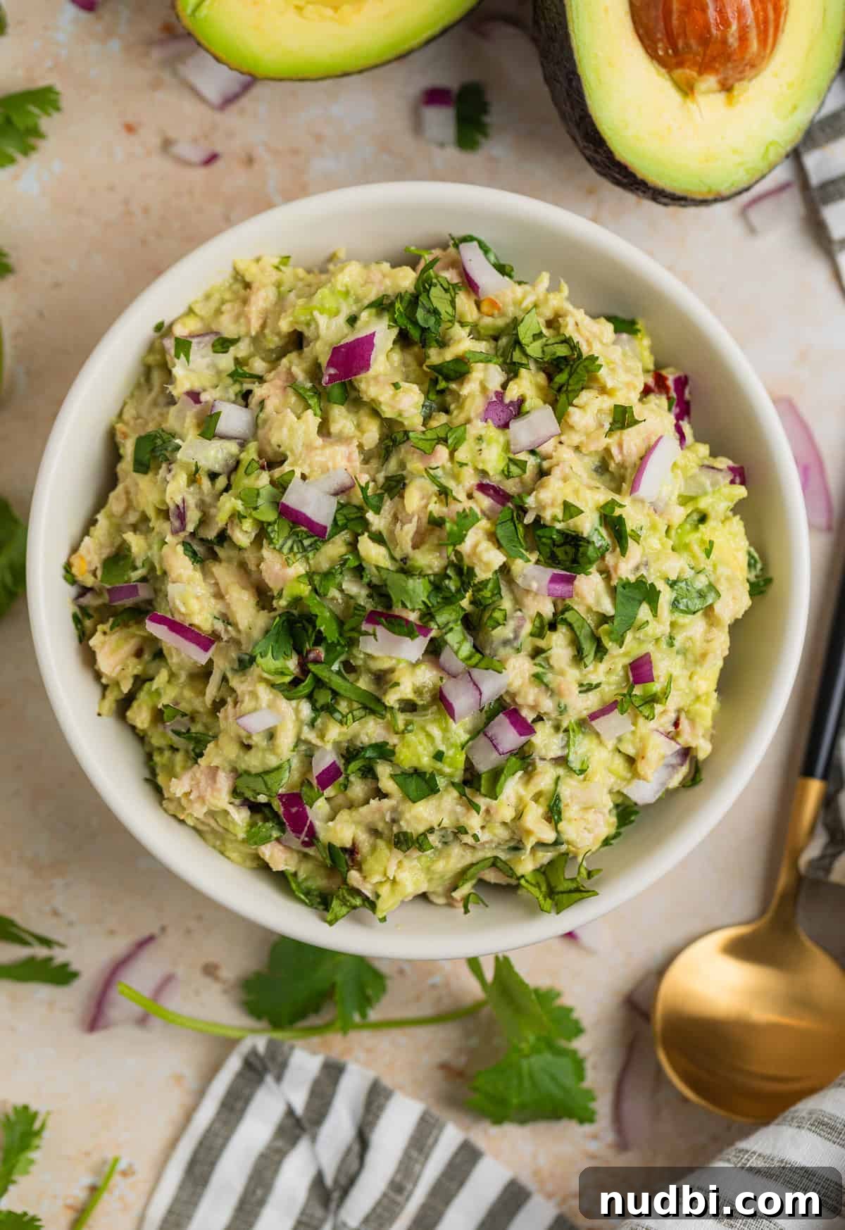 Creamy Avocado Ranch Tuna Salad with Fresh Herbs 3 Avocado ranch tuna salad in dish with spoon, cilantro and linen beside it.