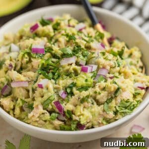 Creamy Avocado Ranch Tuna Salad with Fresh Herbs 8 Bowl with spoon scooping into avocado tuna salad in bowl.