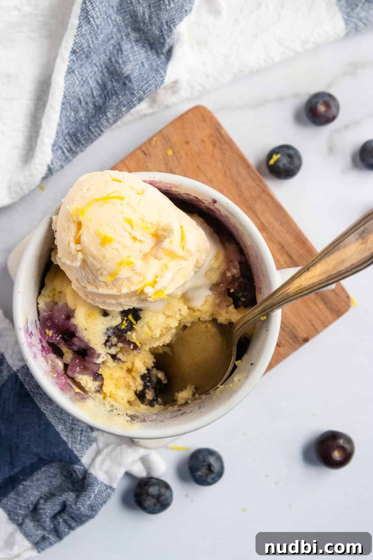 Blueberry Lemon Mug Cake Recipe — Ready in Minutes 6 lemon cake in mug with blueberries and vanilla ice cream.