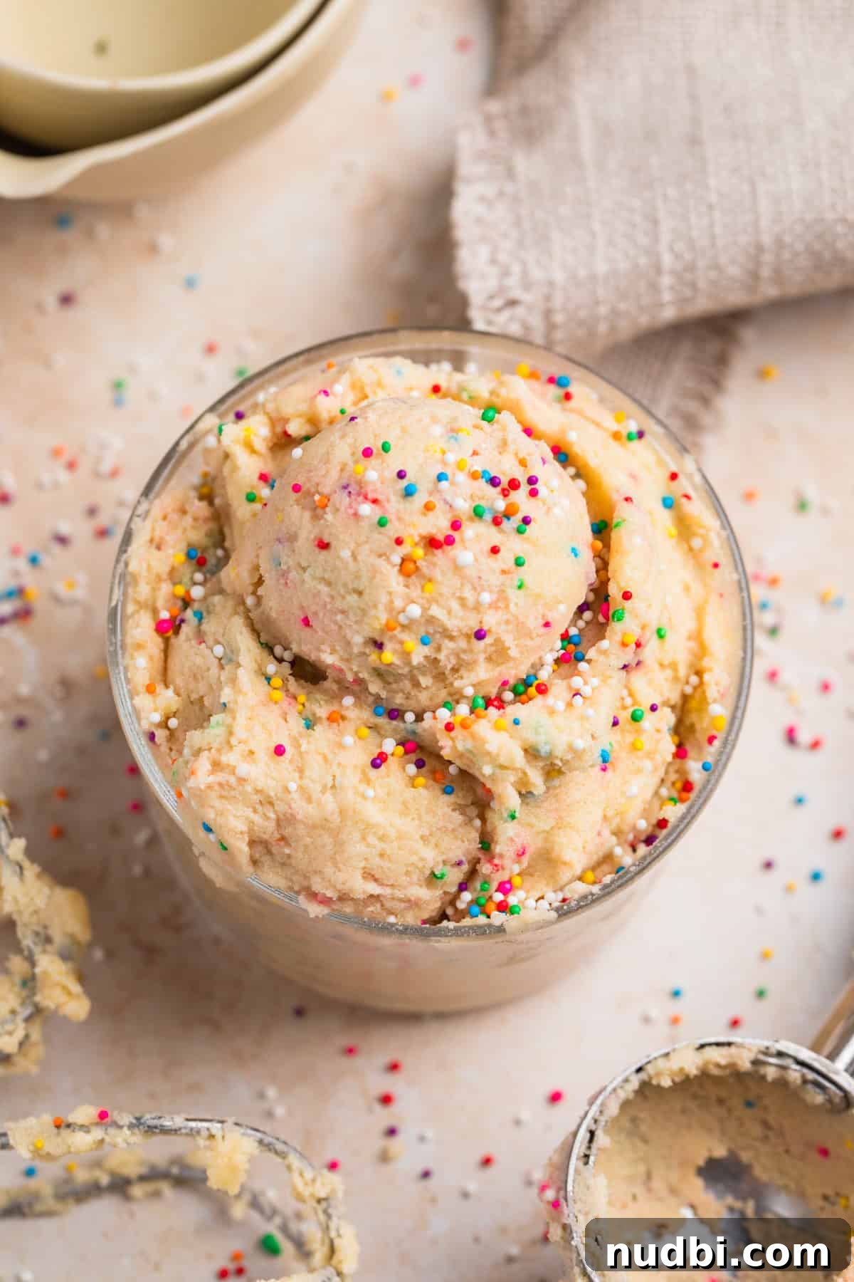Safe-to-Eat Sugar Cookie Dough Recipe for Snacking 2 Edible sugar cookie dough in glass topped with rainbow sprinkles.