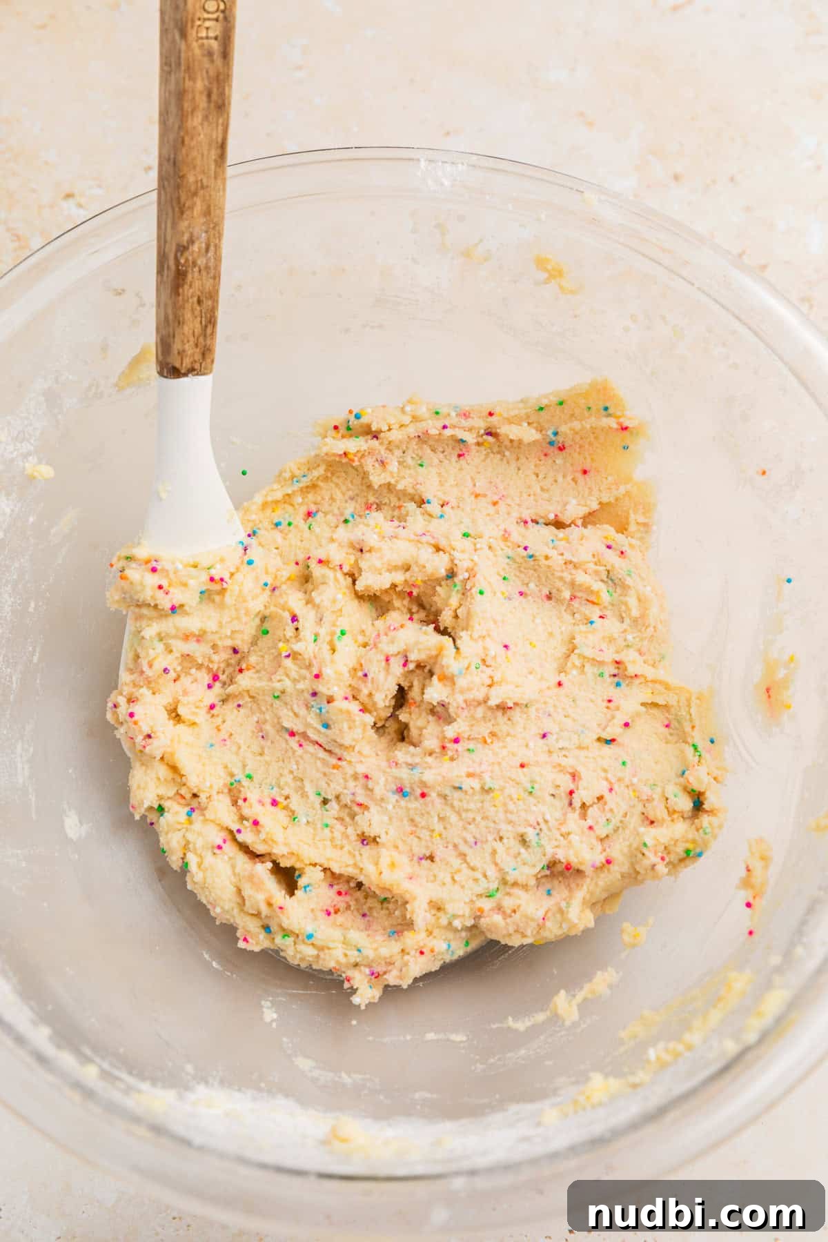 Safe-to-Eat Sugar Cookie Dough Recipe for Snacking 7 Prepared sugar cookie dough with rainbow sprinkles in bowl.