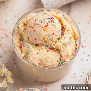 Safe-to-Eat Sugar Cookie Dough Recipe for Snacking 9 Edible sugar cookie dough with sprinkles in cup topped with more sprinkles.