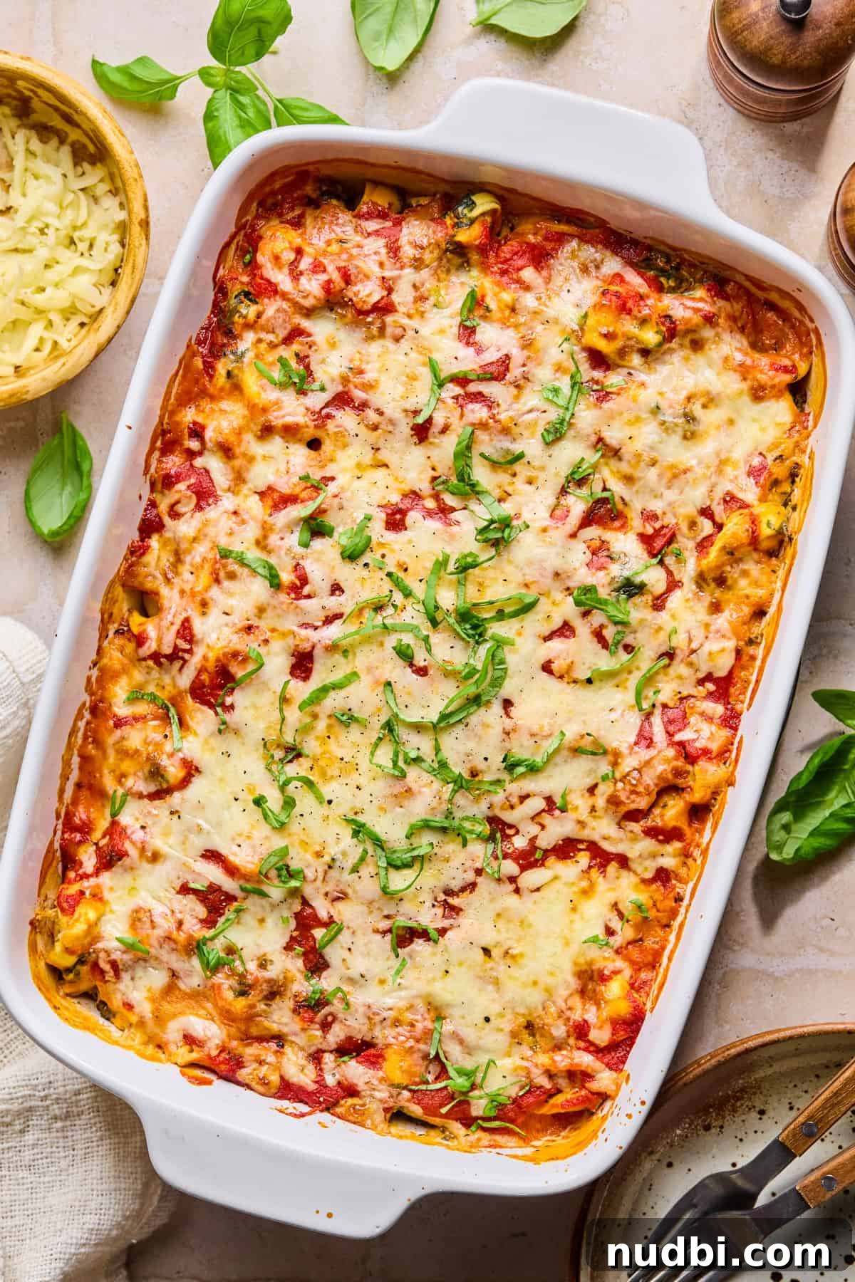 Creamy Spinach and Ricotta Tortellini Bake 10 Spinach and ricotta cheesy tortellini baked pasta with chopped basil on top.