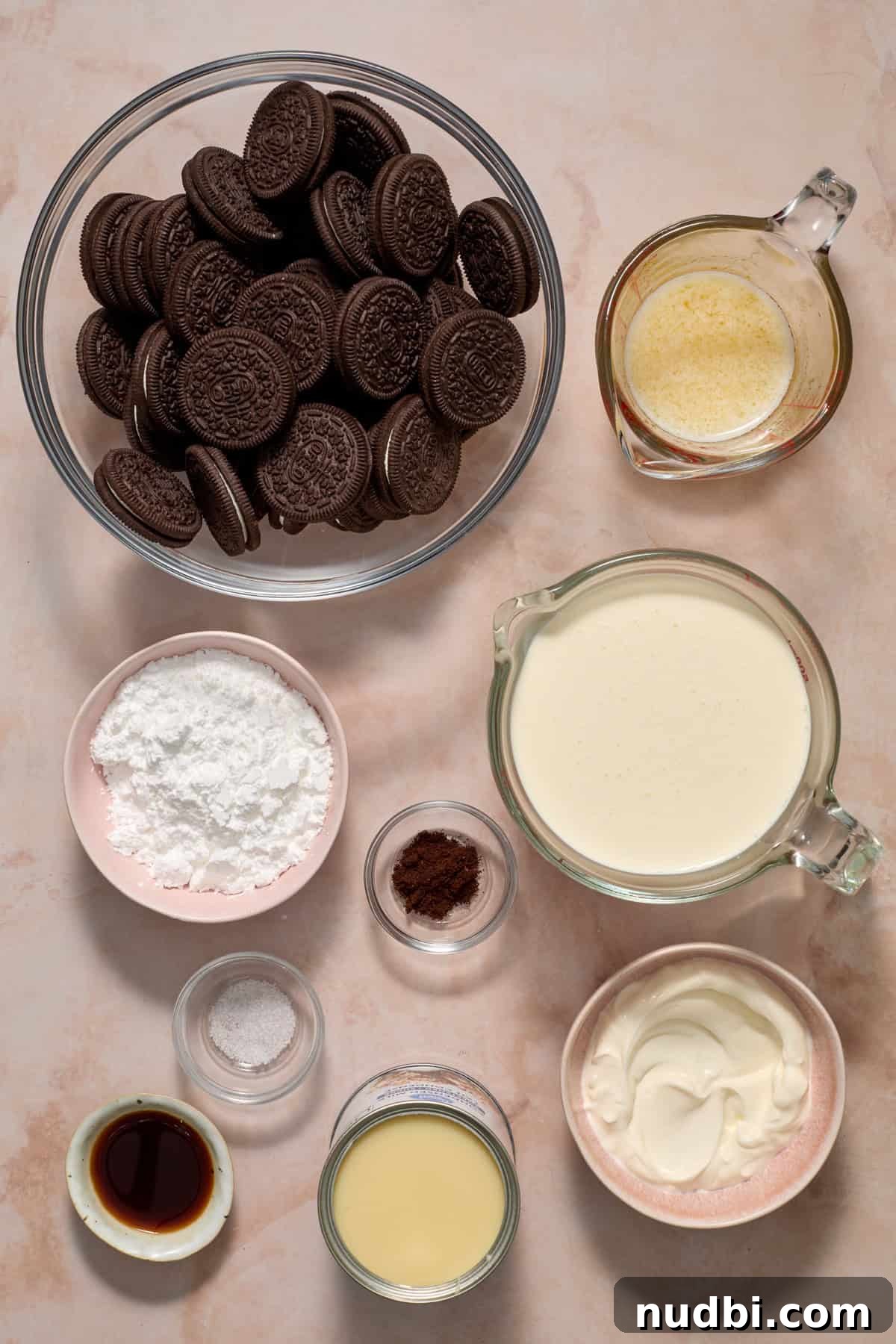 No-Bake Oreo Ice Cream Pie Recipe — Creamy Chocolate Sandwich Dessert 4 Cookies, powdered sugar, butter, cream and other ingredients on surface.