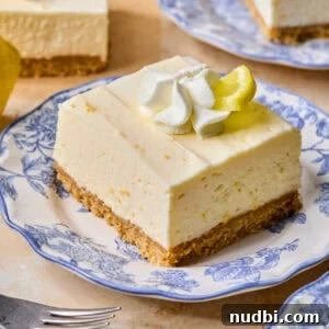 No-Bake Lemon Cheesecake Bars with Zesty Graham Crust 20 Piece of lemon cheesecake bar on plate.