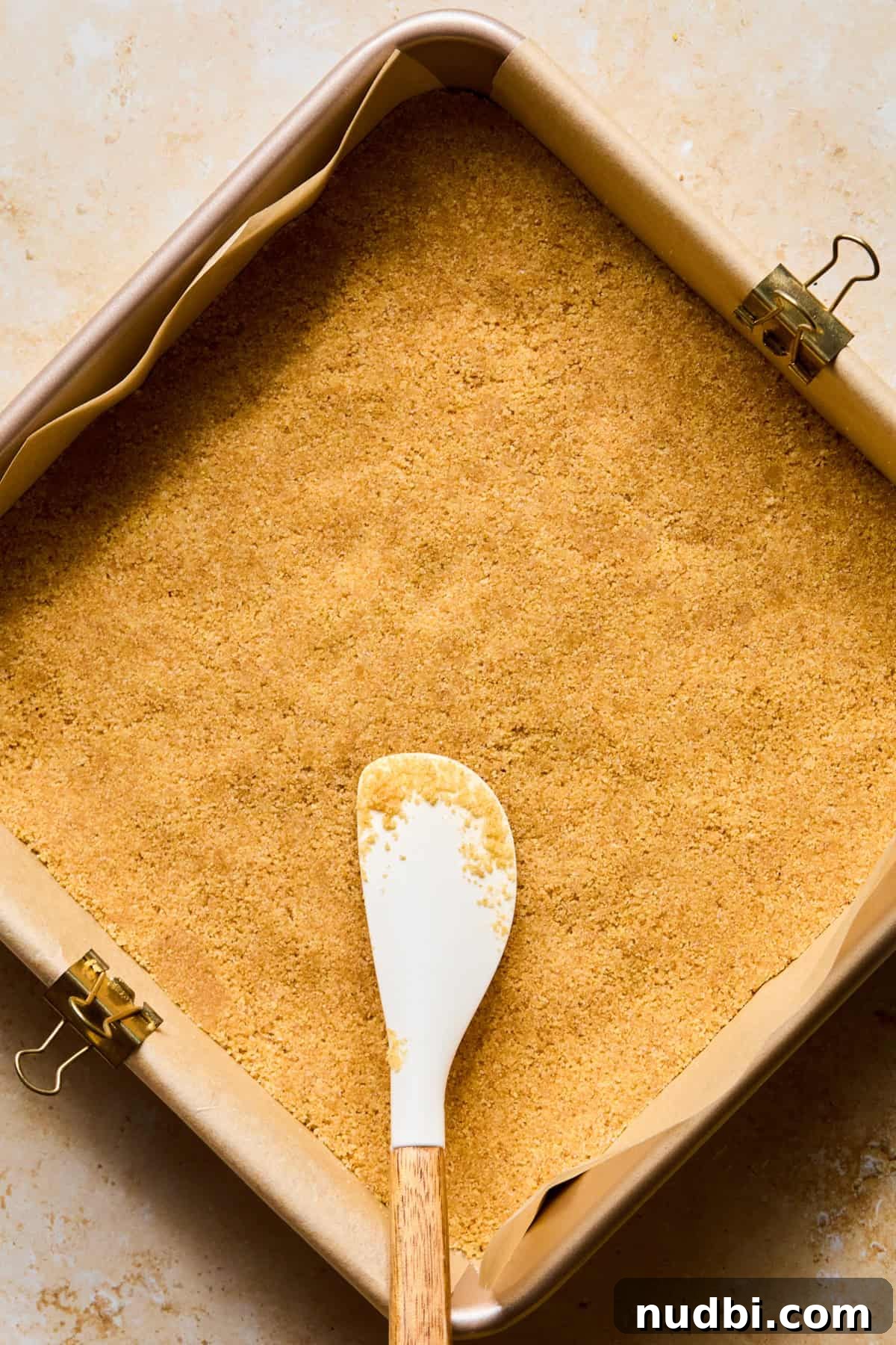 No-Bake Lemon Cheesecake Bars with Zesty Graham Crust 8 Graham crust in pan with parchment paper.
