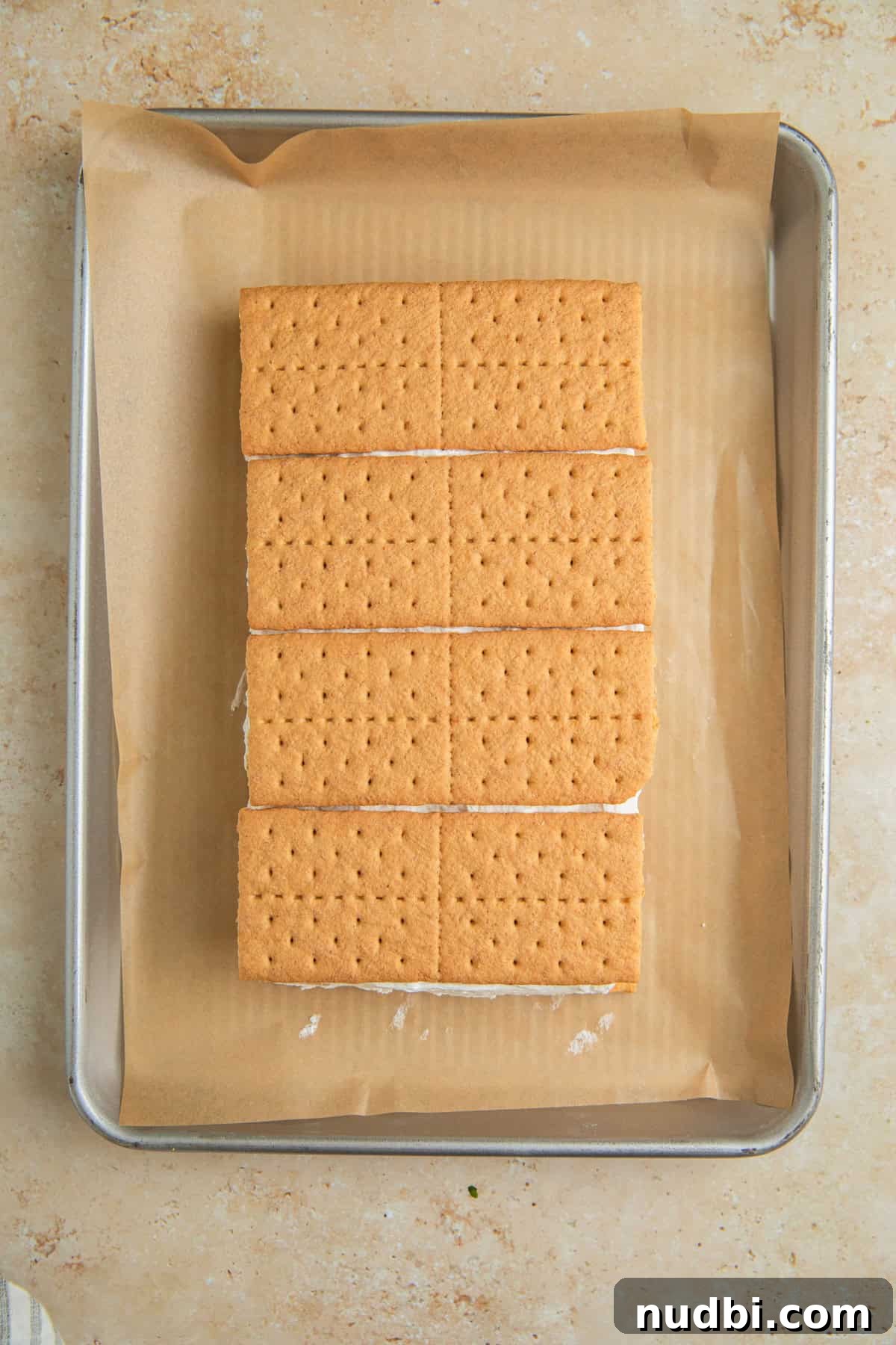 Lemonade Ice Cream Sandwiches Recipe — Refreshing Summer Treat 7 Graham crackers layered over top of lemonade whipped cream on pan with parchment.