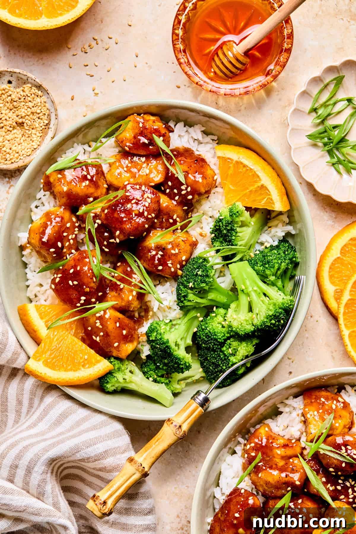 Crispy Spicy Orange Chicken with Tangy Sauce 2 Spicy orange chicken in bowl with rice and broccoli.