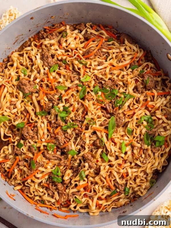 Pan with ground beef ramen topped with green onions.