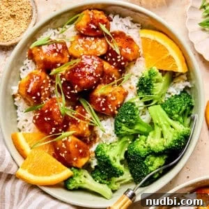 Crispy Spicy Orange Chicken with Tangy Sauce 18 Spicy orange chicken over rice with broccoli and orange slices.