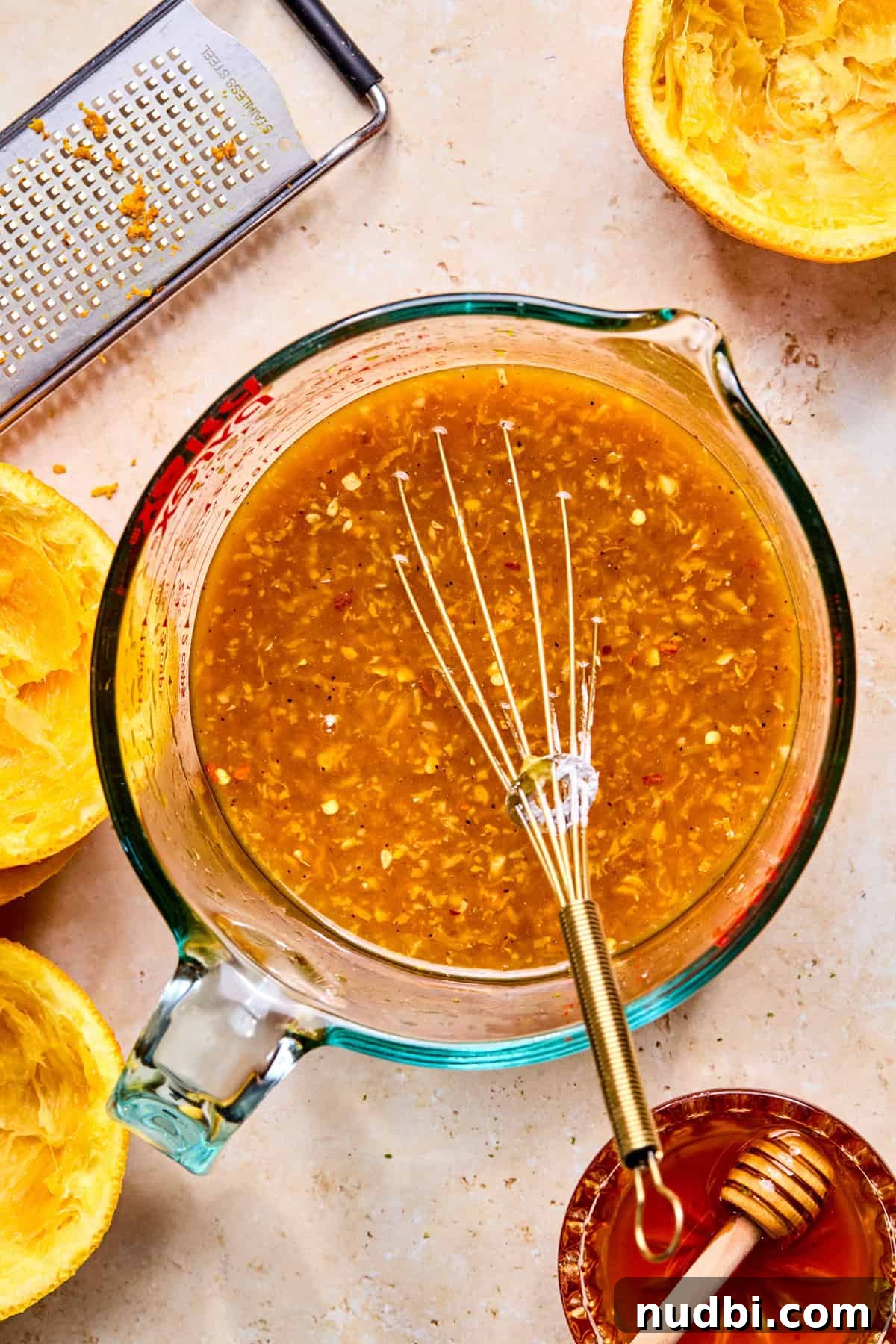Crispy Spicy Orange Chicken with Tangy Sauce 5 Whisked orange chicken sauce mixture in glass measuring cup.