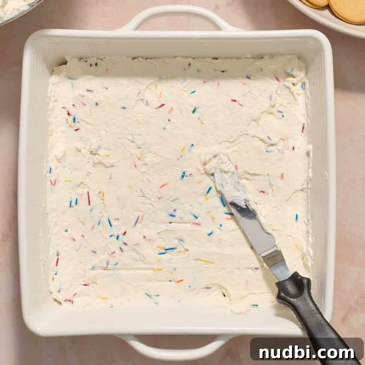 No-Bake Funfetti Icebox Cake Recipe with Whipped Frosting 11 Spread funfetti cream cheese mixture over vanilla cookies with offset spatula.
